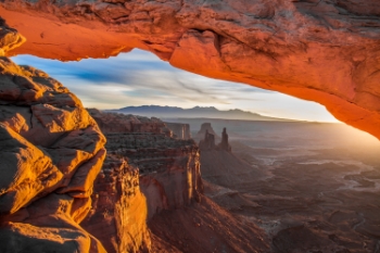 Photographers and nature enthusiasts come from around the globe to photograph the famous mesa at sunrise in Canyonlands National Park in Moab. The sun illuminates the underbelly of the mesa, creating a dramatic fiery appearance.