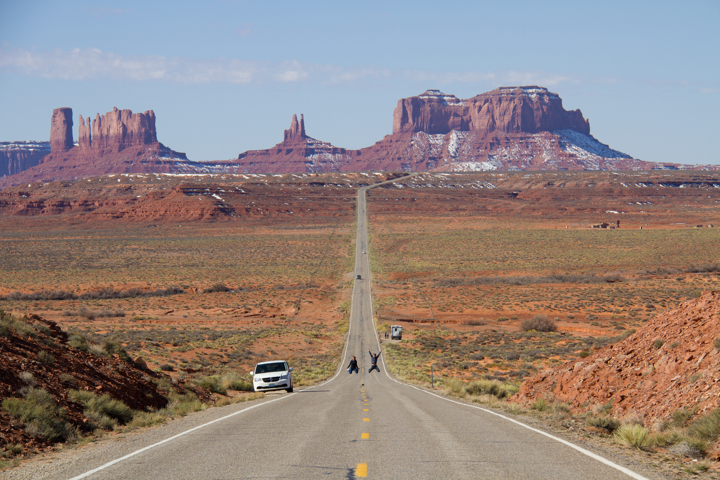 Cute couple taking selfies along the iconic US-163 N with Monument Valley in the background.
