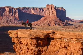 A Navajo man sits on his horse Pistol overlooking the Monument Valley. This cliff overlook is John Ford’s Point, named after the famous Hollywood director who shot seven western movies in Monument Valley, including several with the actor John Wayne.