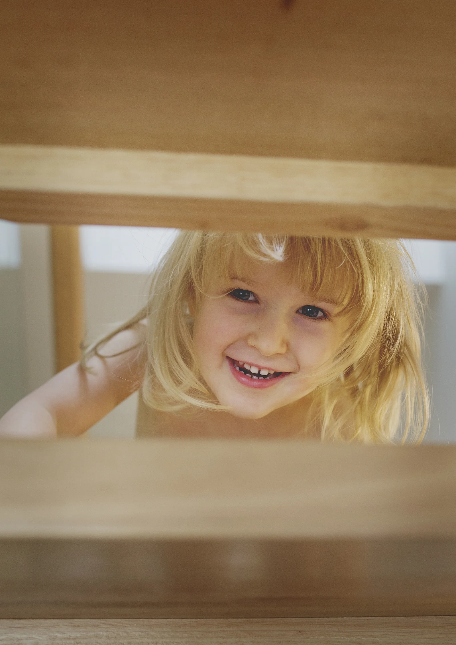 Little girl playing peek-a-boo on the staircase