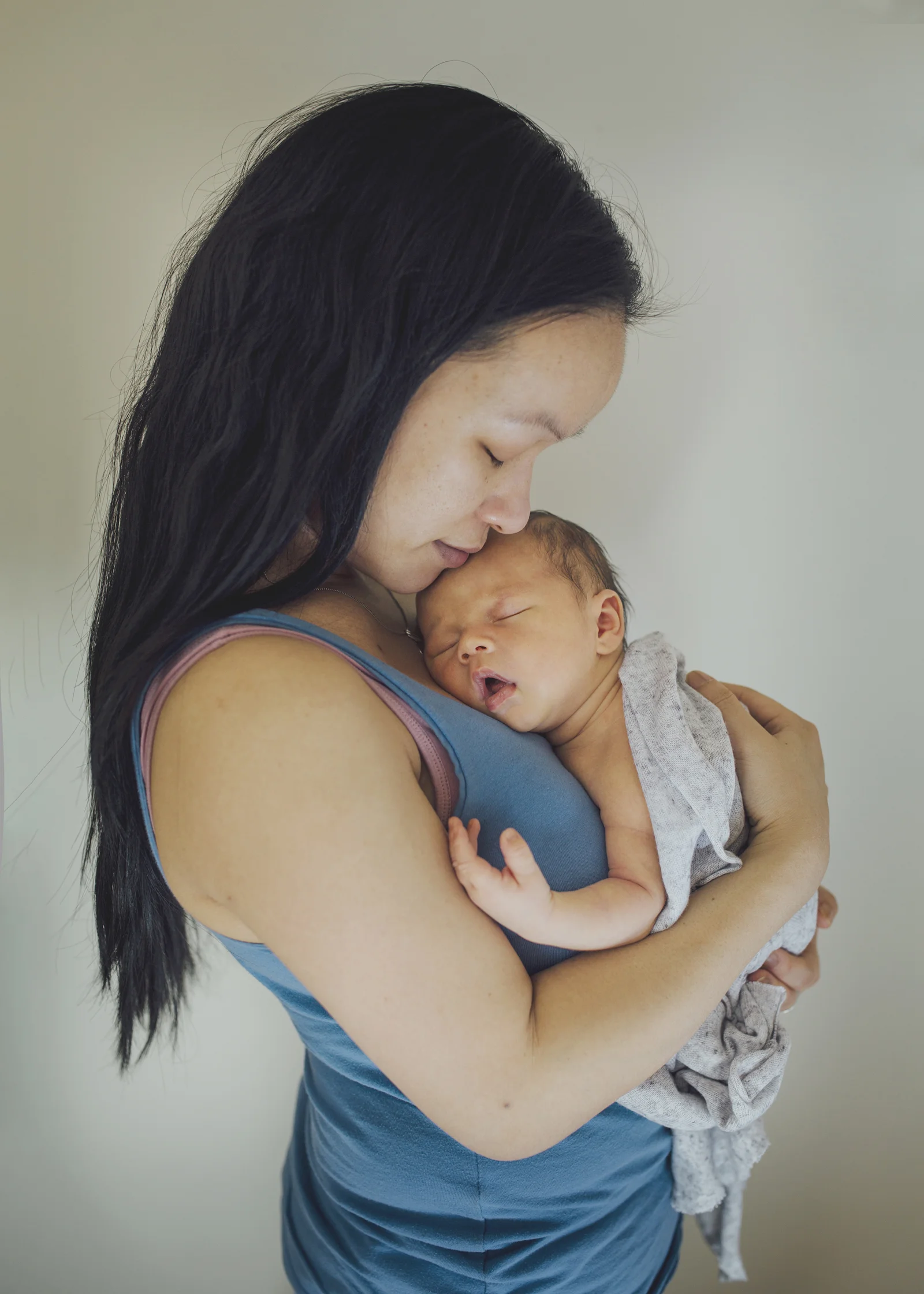 New mother cuddling her newborn baby son