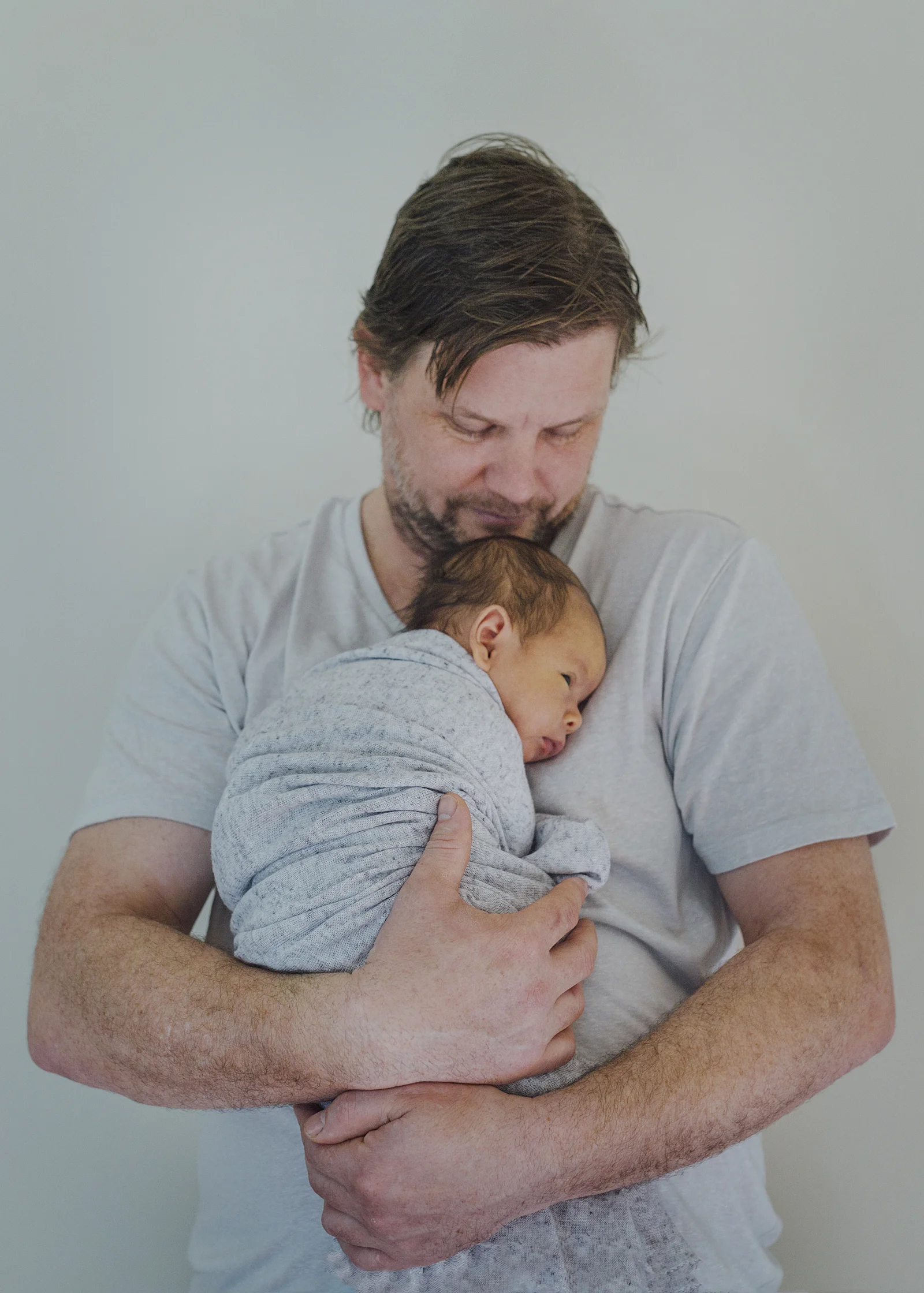 New Dad cuddling his newborn baby son