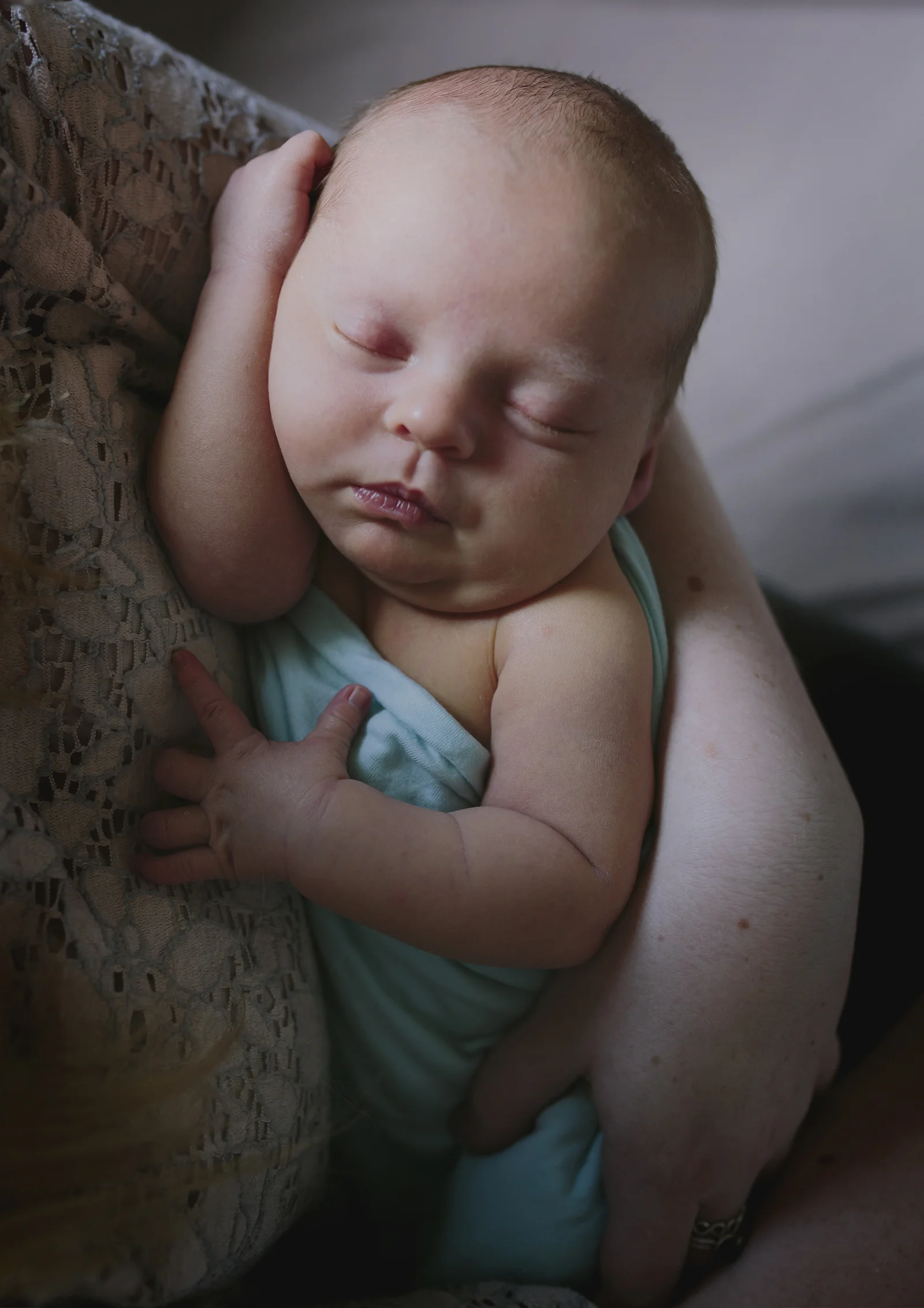Precious Newborn Baby Boy nestled in his mother's arms