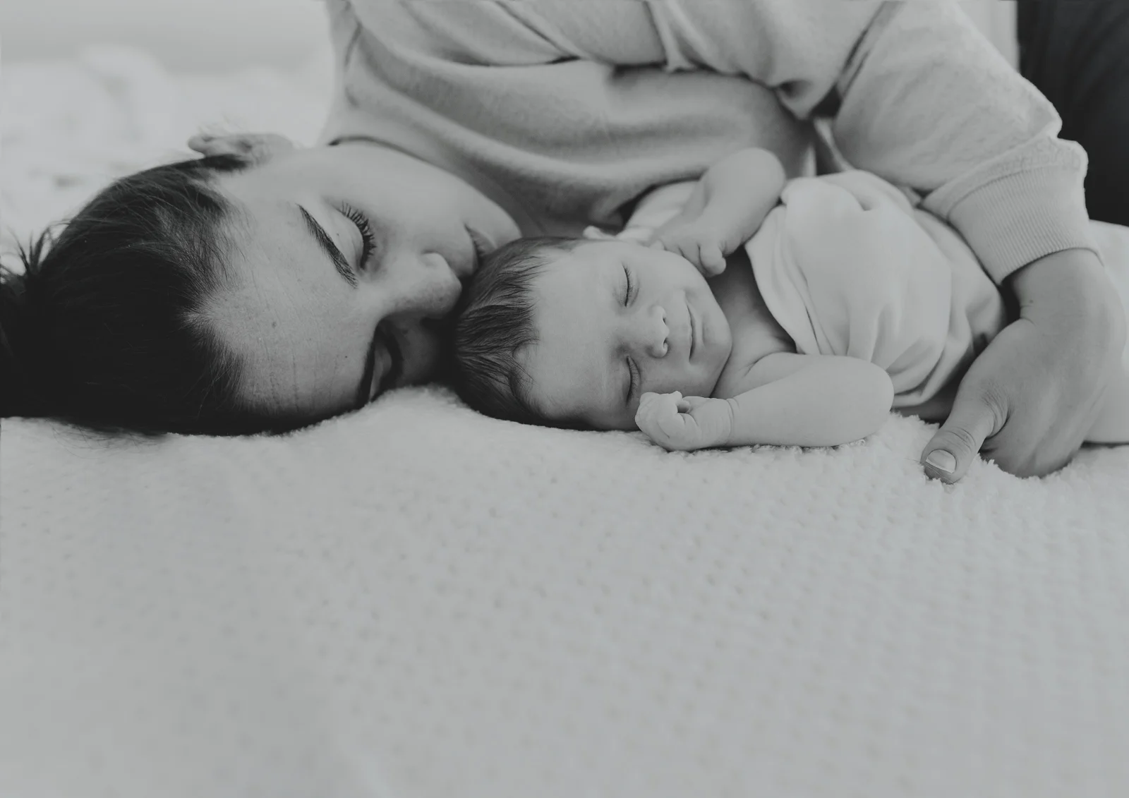 New mother cuddling her newborn baby daughter