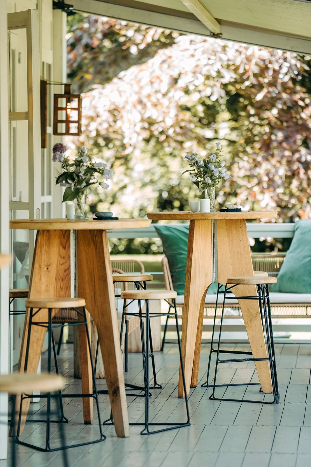 houten receptietafels met bloemstuk op