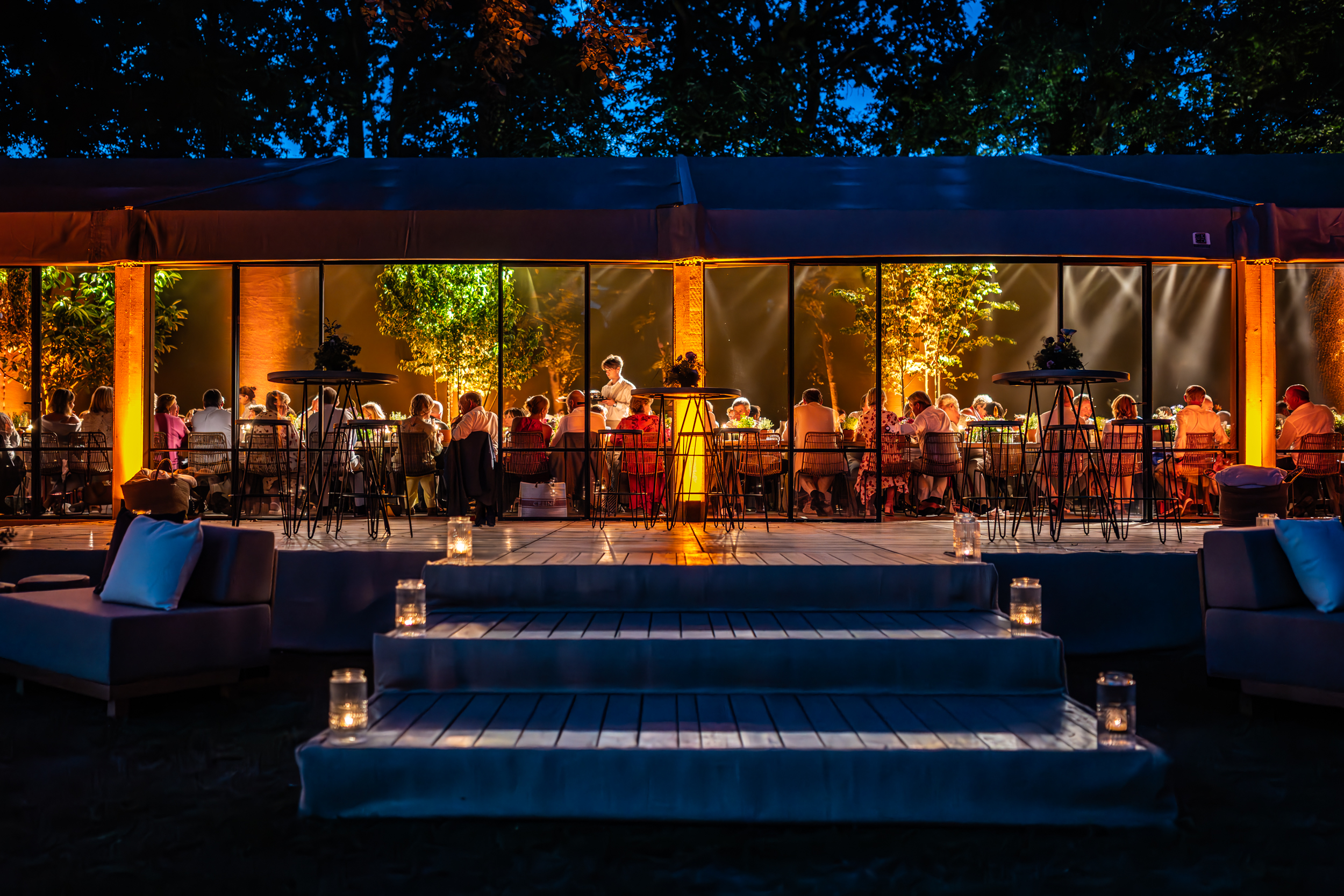 mensen aan tafel in een tent tijdens een tuinfeest