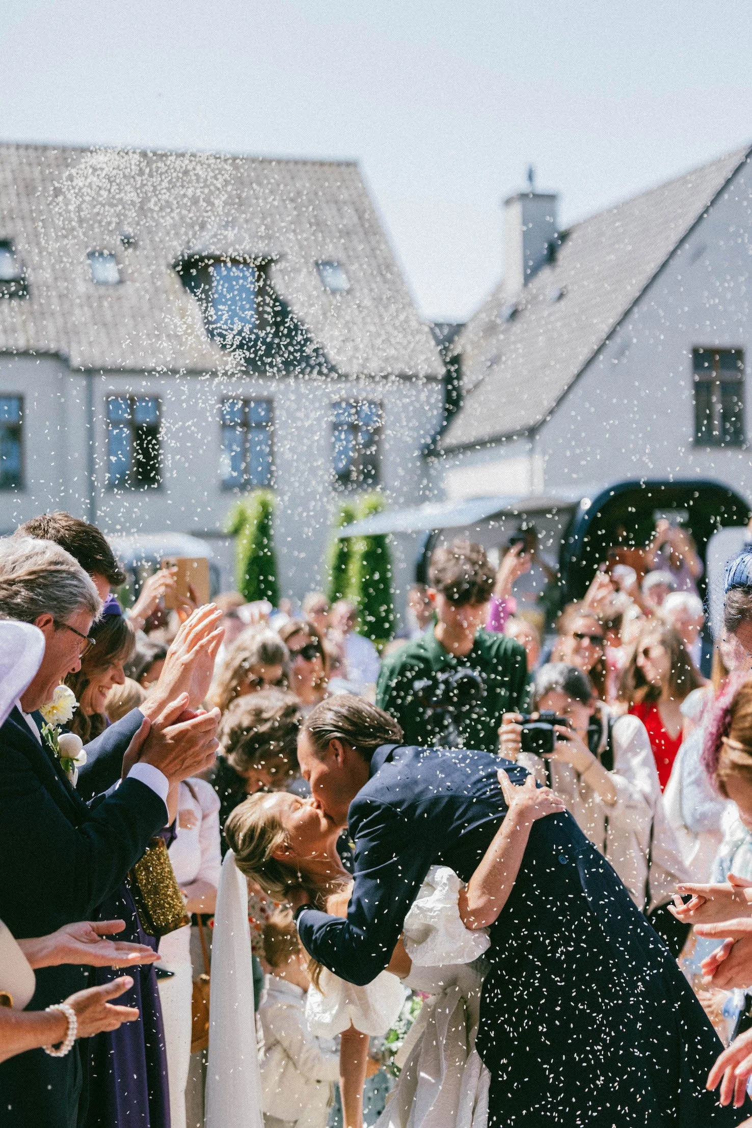 bruidspaar kust terwijl gasten rijst gooien
