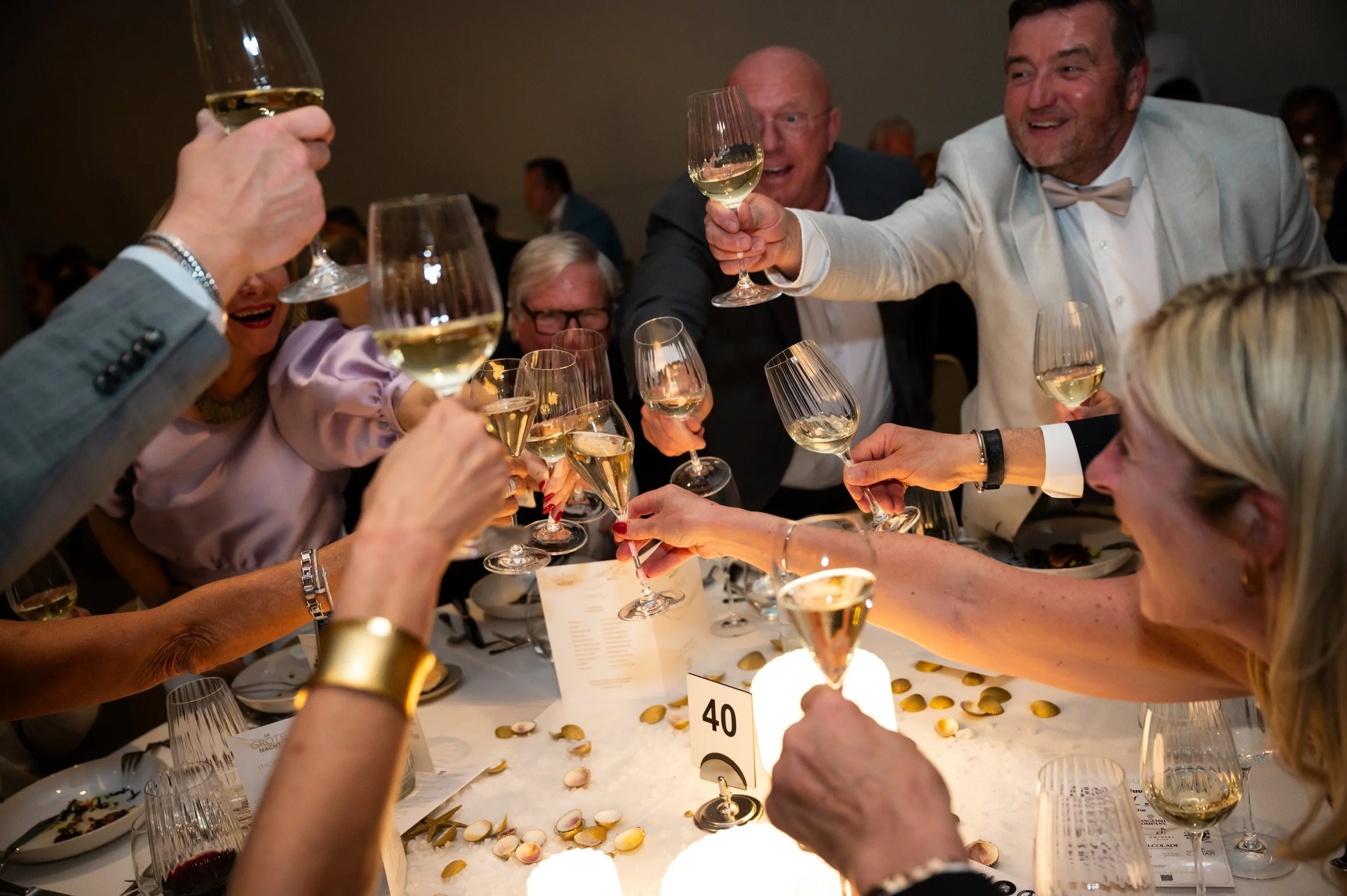 mensen klinken met glazen aan tafel