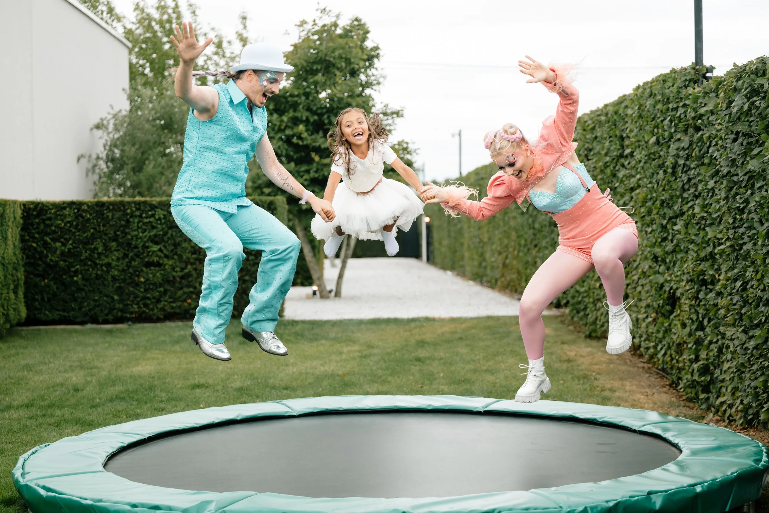 kindje die met entertainers op trampoline springt