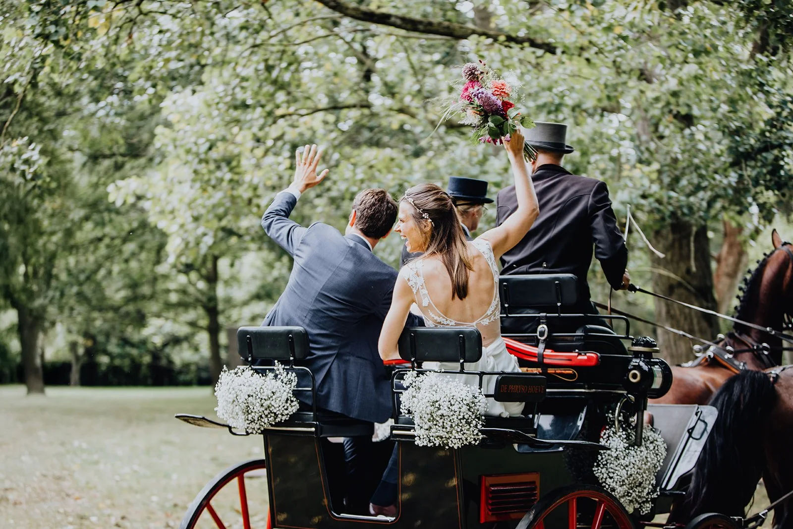 bruidspaar in paardenkoets op huwelijk