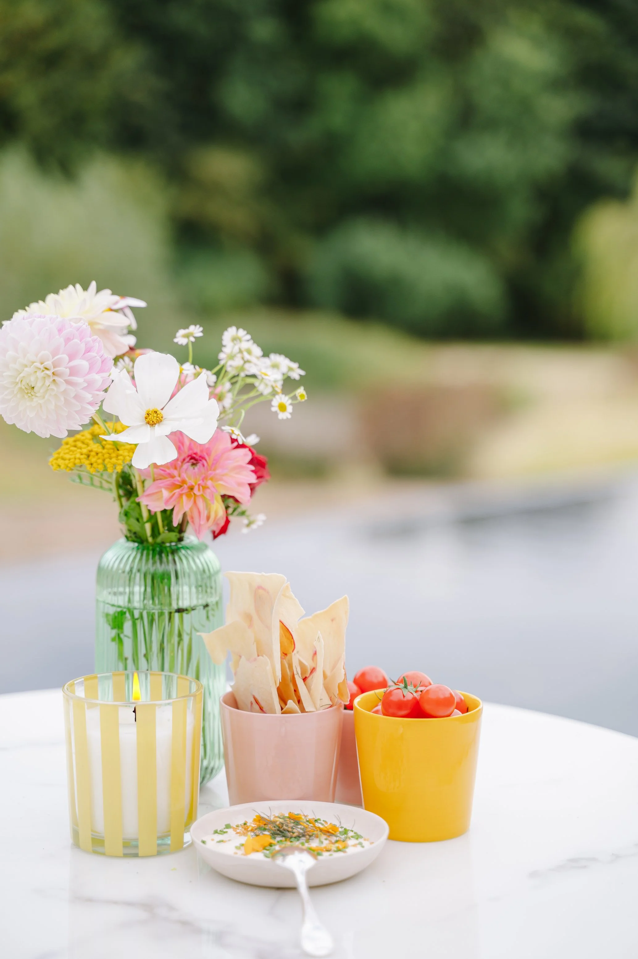 detail van hapje met tomaatjes en bloemen op een gedekte tafel