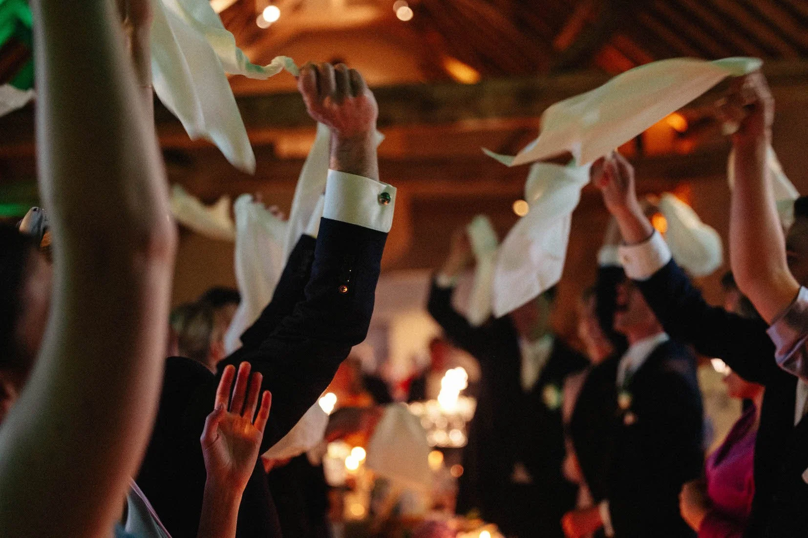 gasten zwaaien met servetten tijdens een trouwfeest