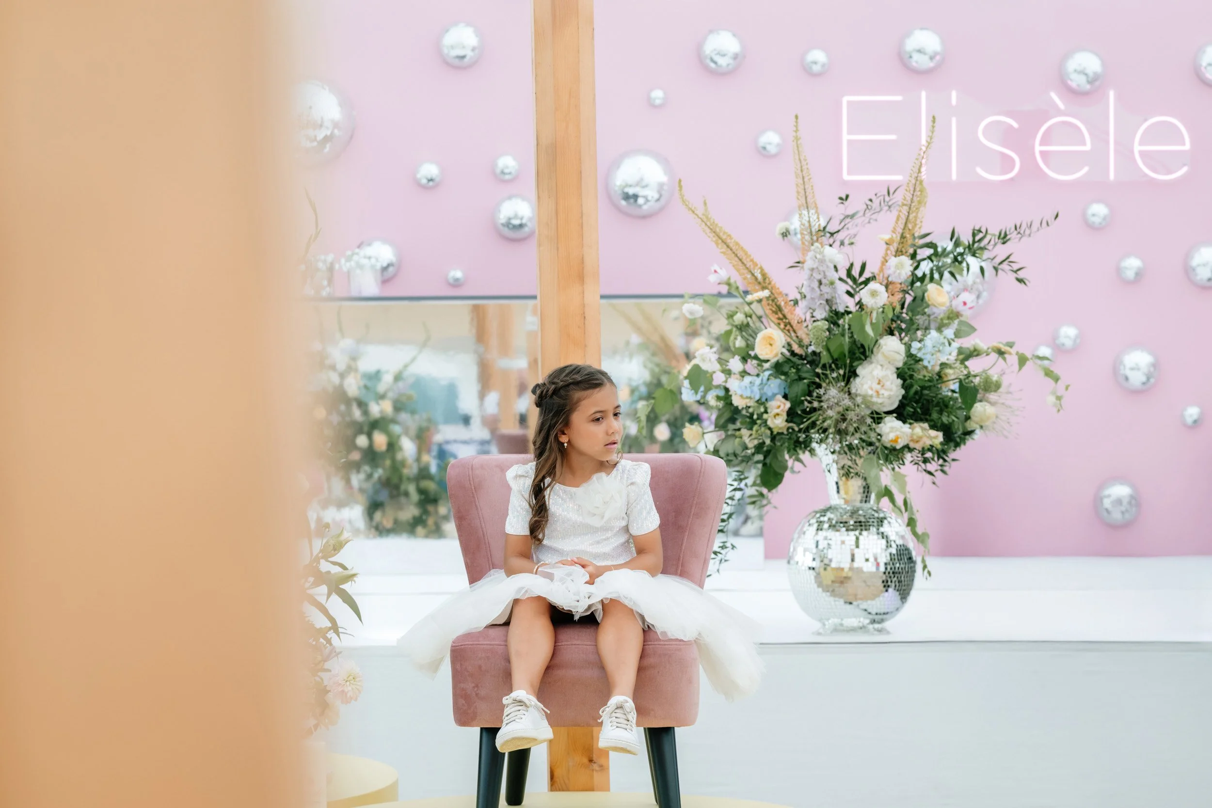 meisje die op een roze stoel zit