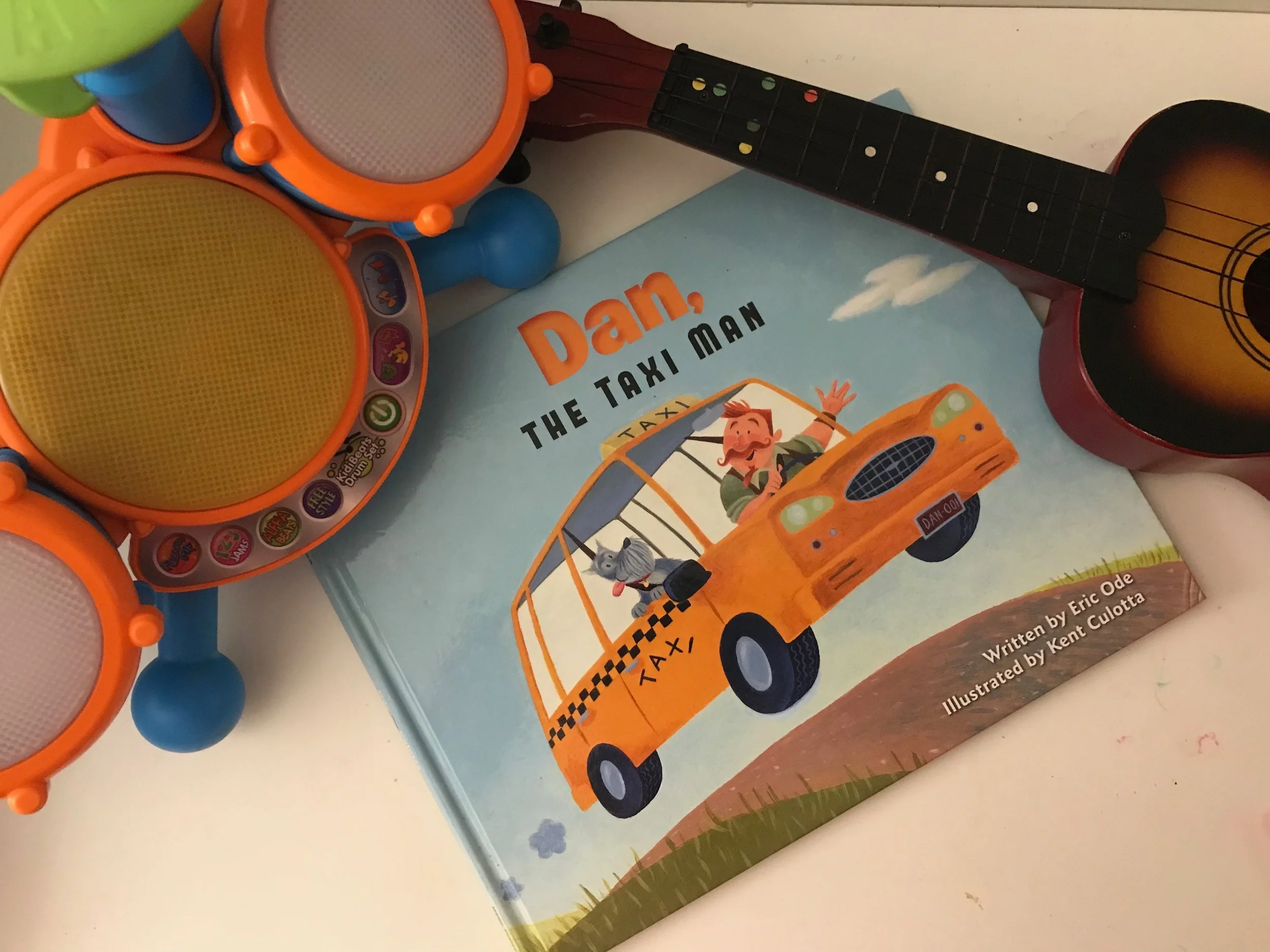 "Dan, Dan the Taxi Man... Going to the show and picking up the band... climb inside while you still can, with Dan 'BEEP, BEEP' The Taxi Man" So begins this book filled with musical sounds, chants and rhymes your kids will love to sing along with as you read. After reading (or singing) this book, grab your own musical instruments and make your own band. Dancing in the kitchen, may ensue... But the kids in your life are sure to have fun! Find Dan the Taxi Man Here