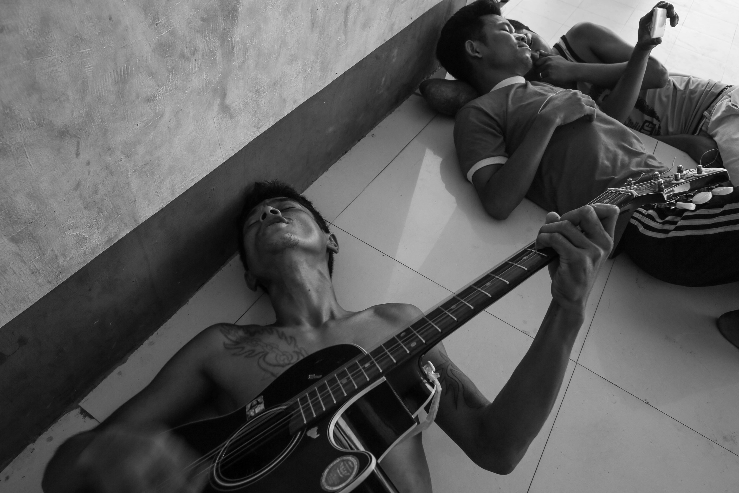Brang San Aung, left, in his thirties, plays the guitar while singing with friends at the Aung Mintha rehab camp. Music seems to be the best way to pass the time in rehab. Brang San Aung is HIV positive and used heroin for seven years. He died from unknown causes months after this photo was taken.