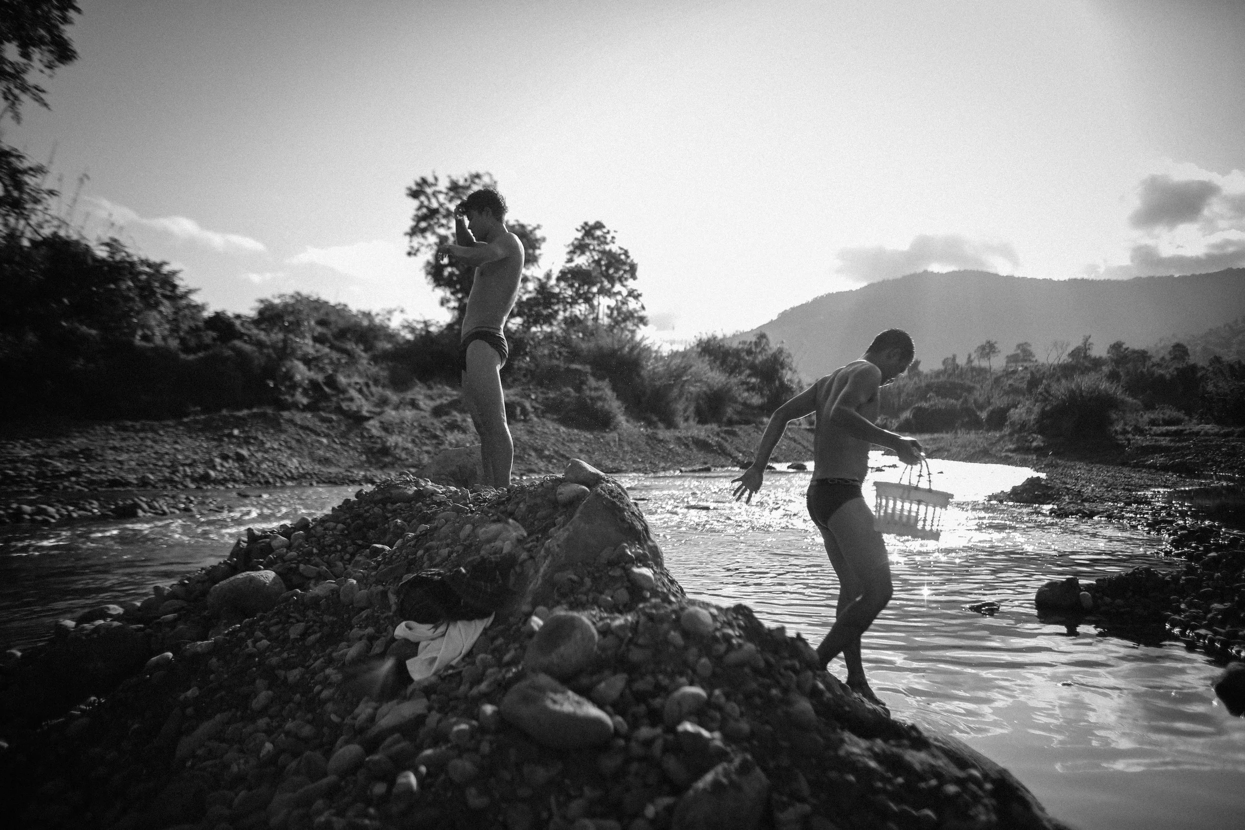 Two recovering addicts at the Aung Mintha rehab play in a stream near the rehab camp. The cold water eases their withdrawal pains.