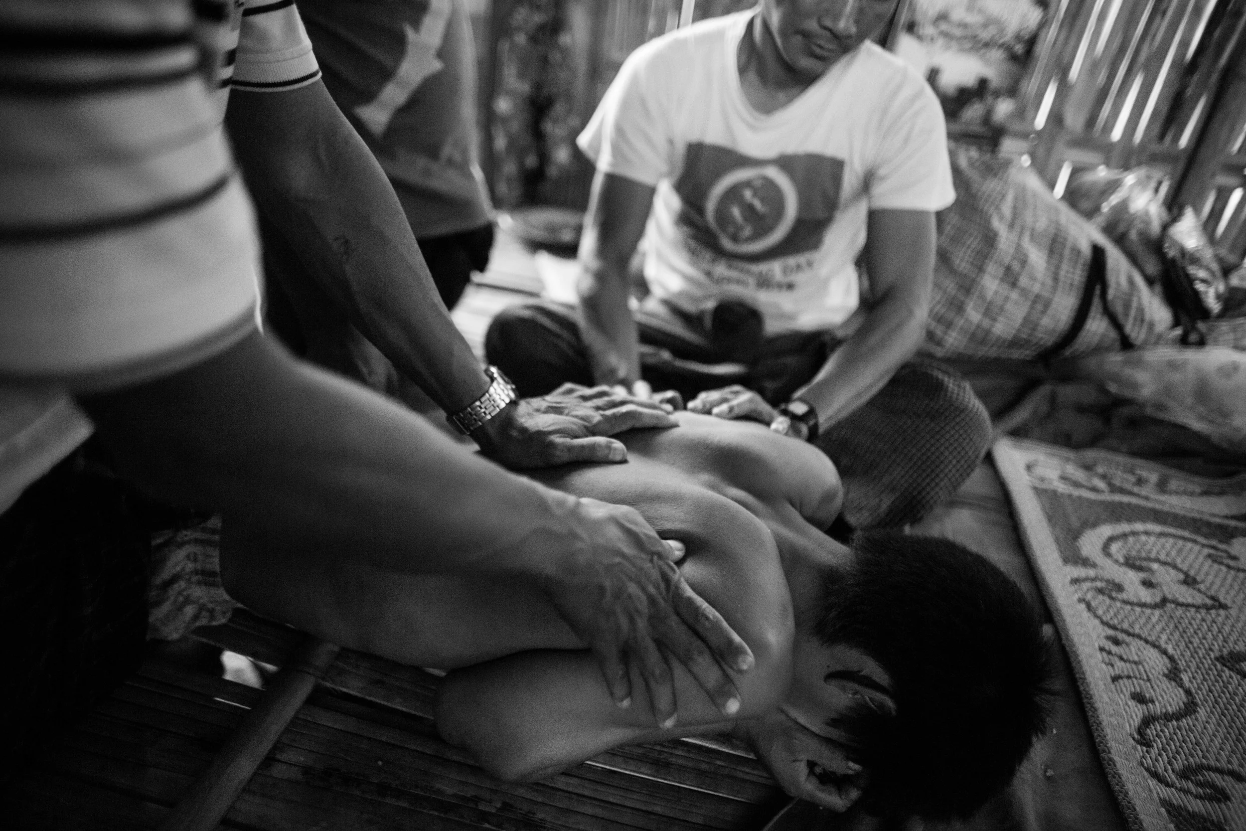 YCC staff members massage Hkun Aung, 34 while suffers through withdrawal pains. Hkun Aung has been an addict for 16 years and this is his third day in rehab.