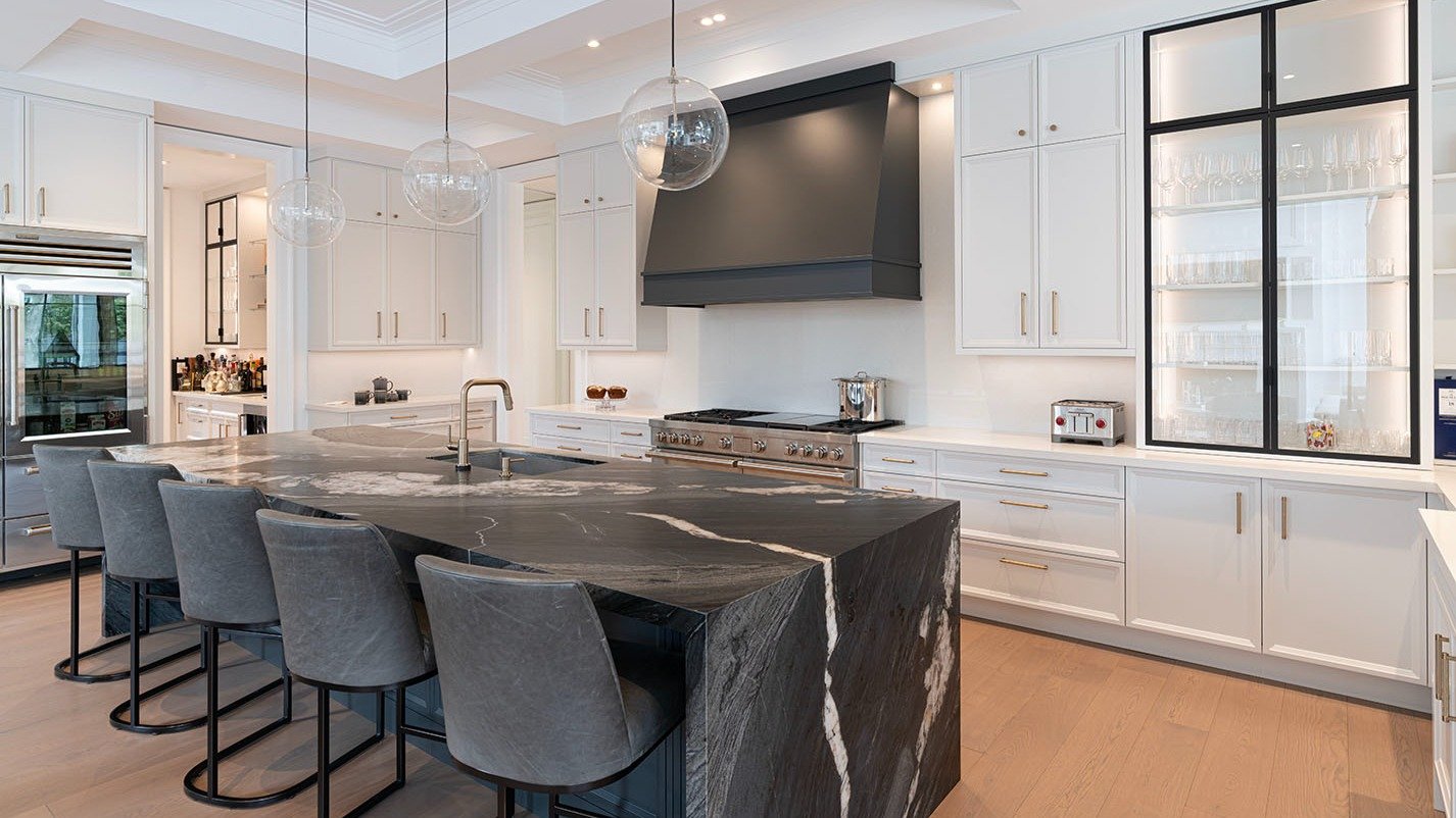 This kitchen has it all.

From the dramatic marble island and custom black hood to the glass display cabinets and hidden bar nook, every detail is thoughtfully designed.

✔️ Waterfall-edge island with bold veining
✔️ Matte black range hood as a focal