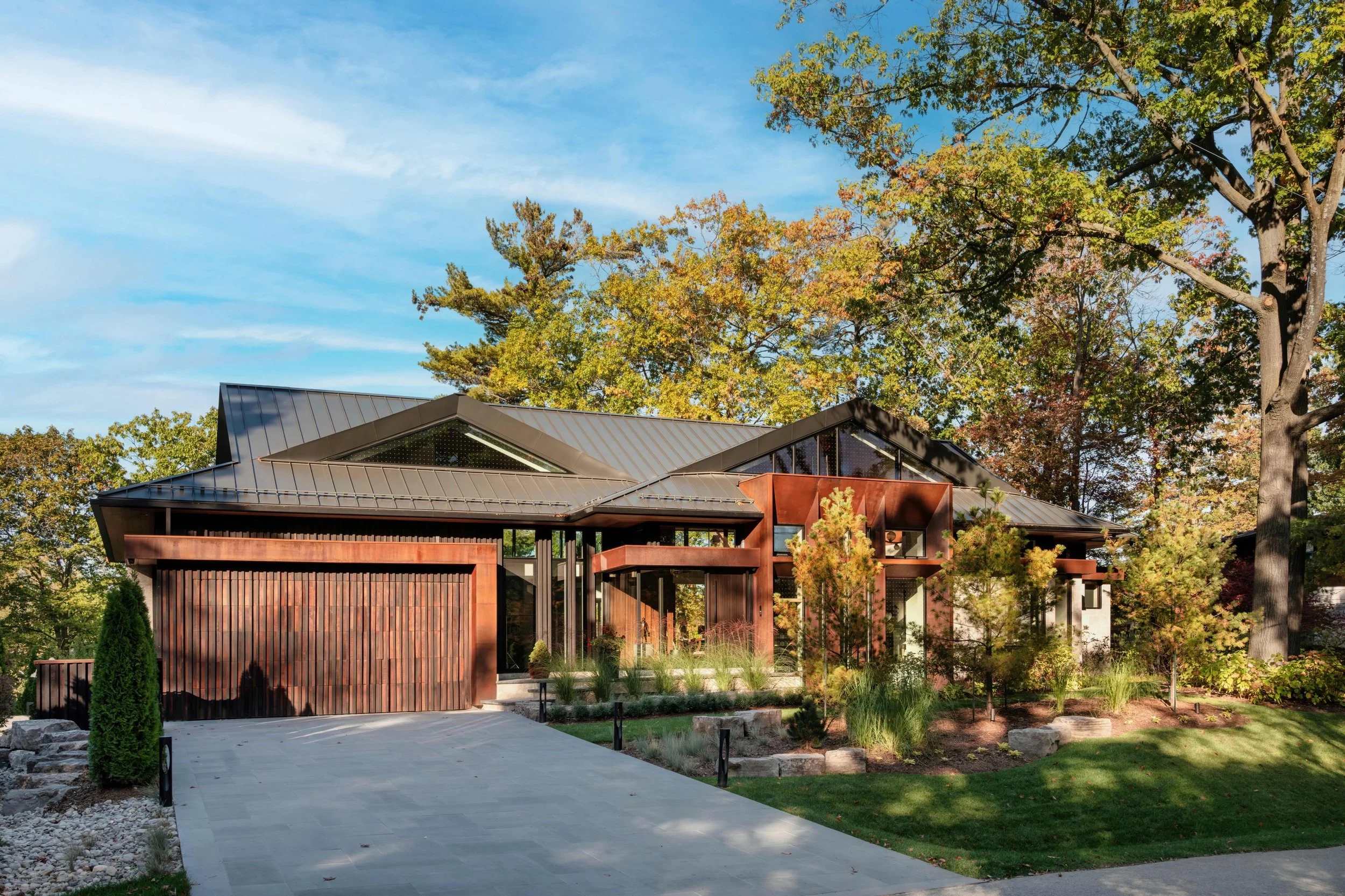 A hidden gem, finally revealed.

Grounded in natural materials and framed by a mature canopy, the residence layers weathering steel, vertical wood screening, and expansive glazing beneath a sculptural standing seam roof.

A modern home designed to fe