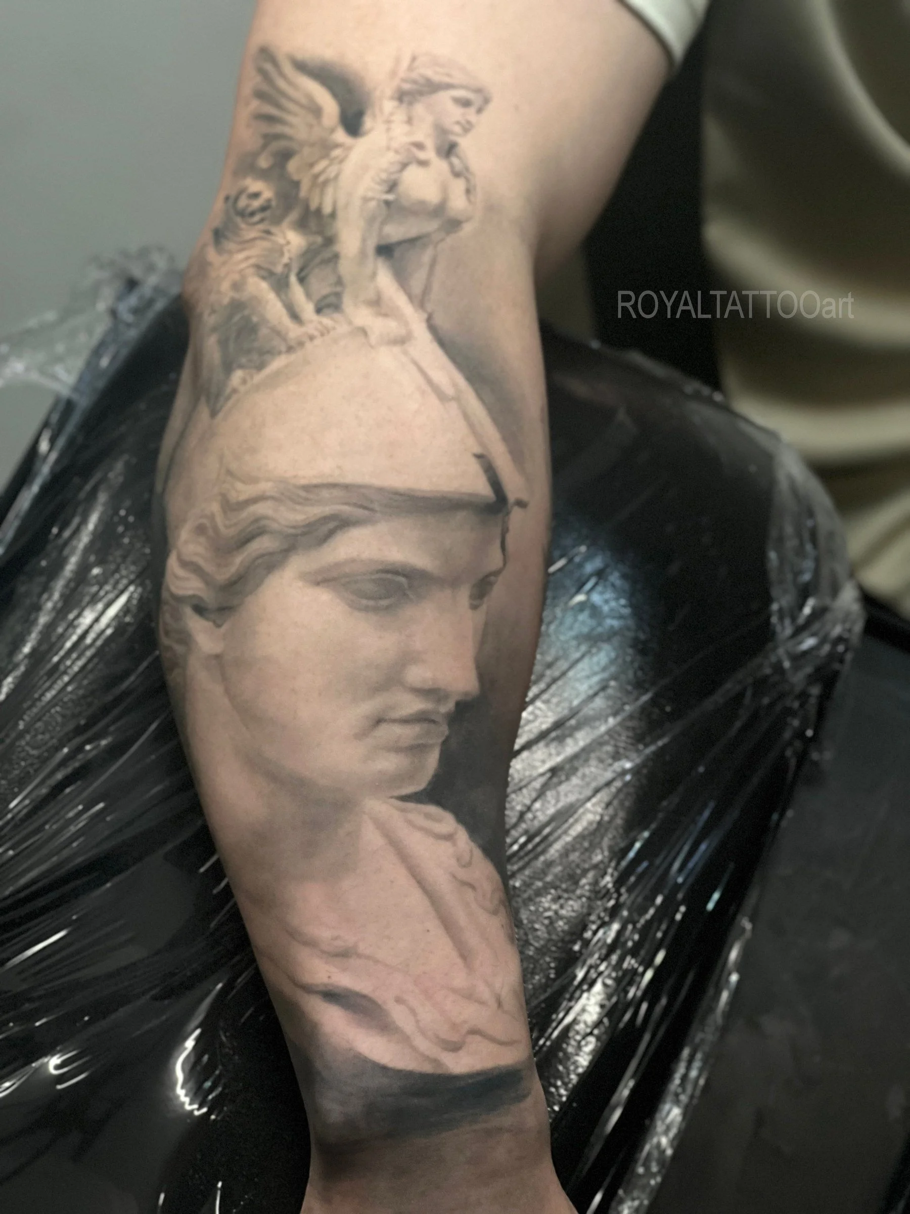 Black and grey Athena mythology portrait tattoo, inspired by classical sculpture with realistic stone texture and fine art shading by Royal Jafarov in NYC.