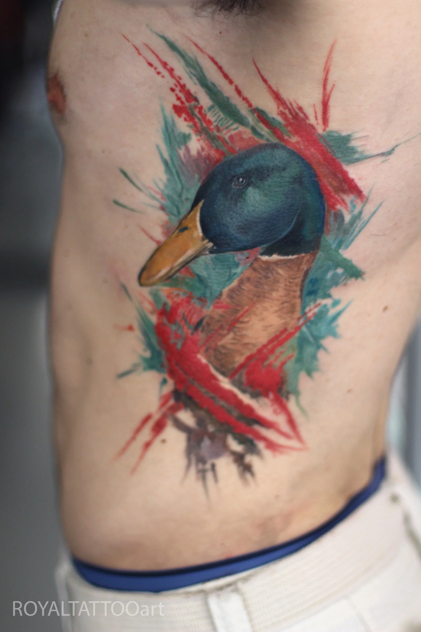 Unique duck pet portrait tattoo in vibrant abstract watercolor style, tattooed in NYC. Royal Tattoo Art transforms a beloved pet duck into a colorful, artistic masterpiece — a one-of-a-kind watercolor animal tattoo that stands out as a true statement