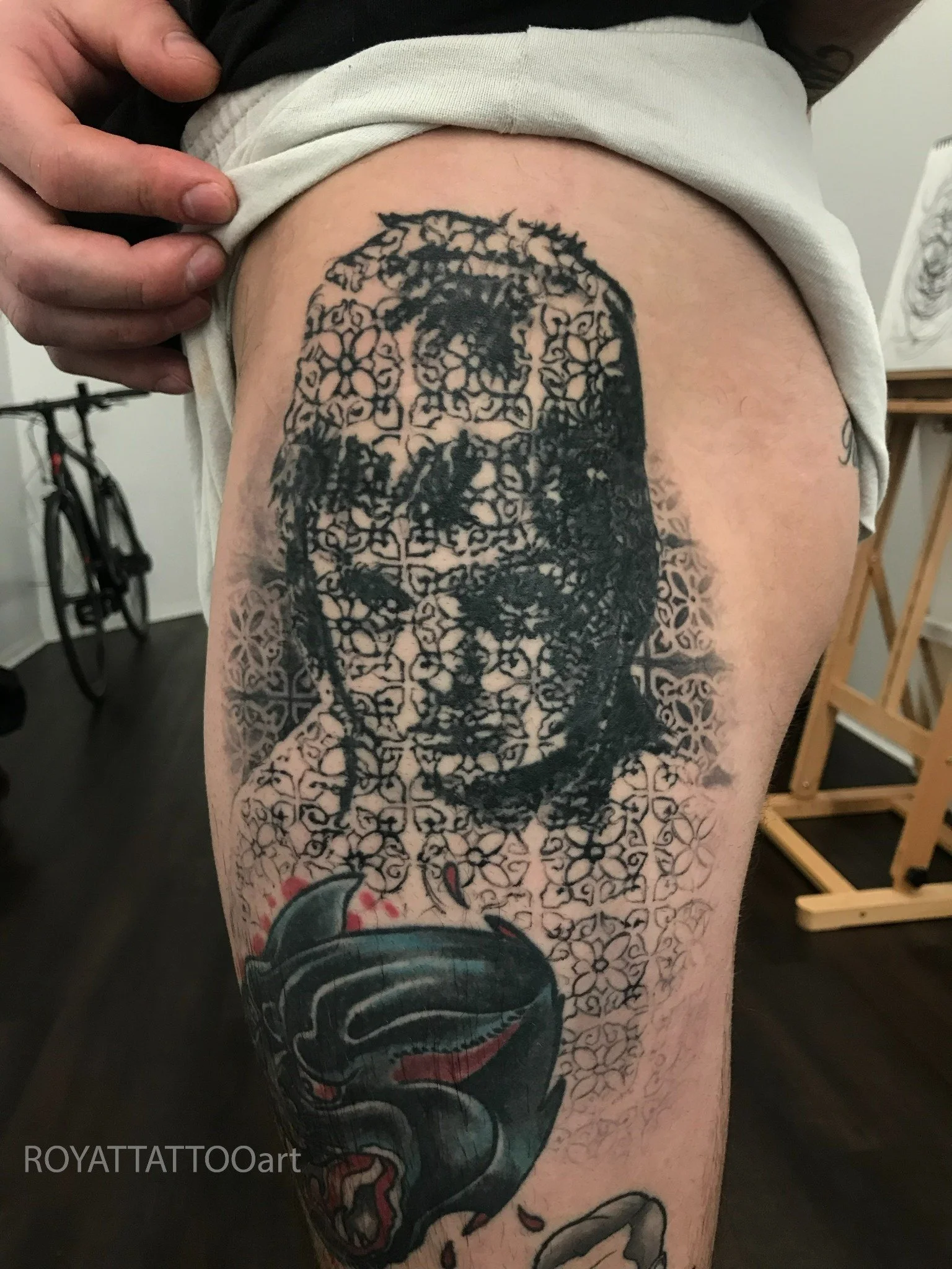 Black and grey ornamental face cover-up tattoo with detailed pattern work and layered texture, created by Royal Tattoo Art in NYC.