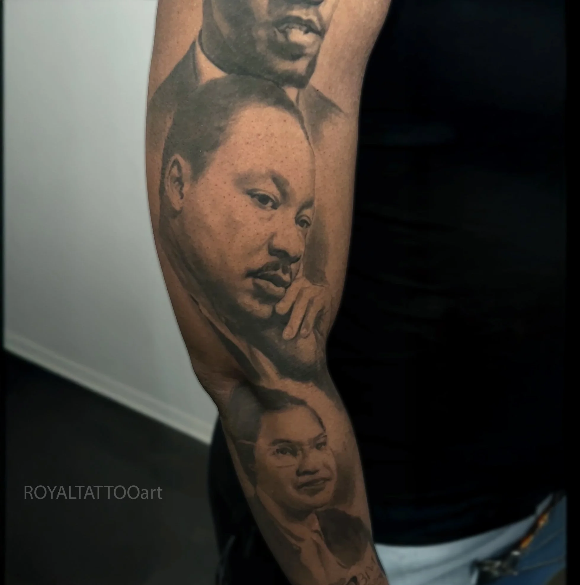 Black and grey Martin Luther King Jr. portrait tattoo sleeve, designed as a historical tribute with realistic shading by Royal Jafarov in Manhattan.