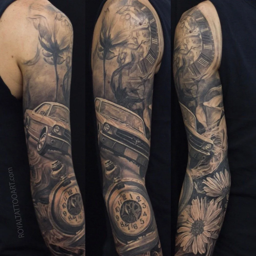 Black and grey realism sleeve tattoo featuring a Mustang car, clock, flowers, and portrait elements in a detailed custom composition.
