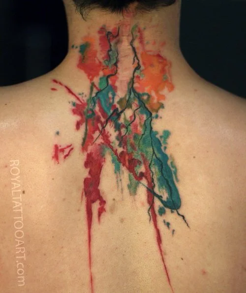 Colorful abstract watercolor brushstroke tattoo with red, teal and orange splatter on upper back and spine, expressive ink art by Royal Jafarov at Royal Tattoo Art
