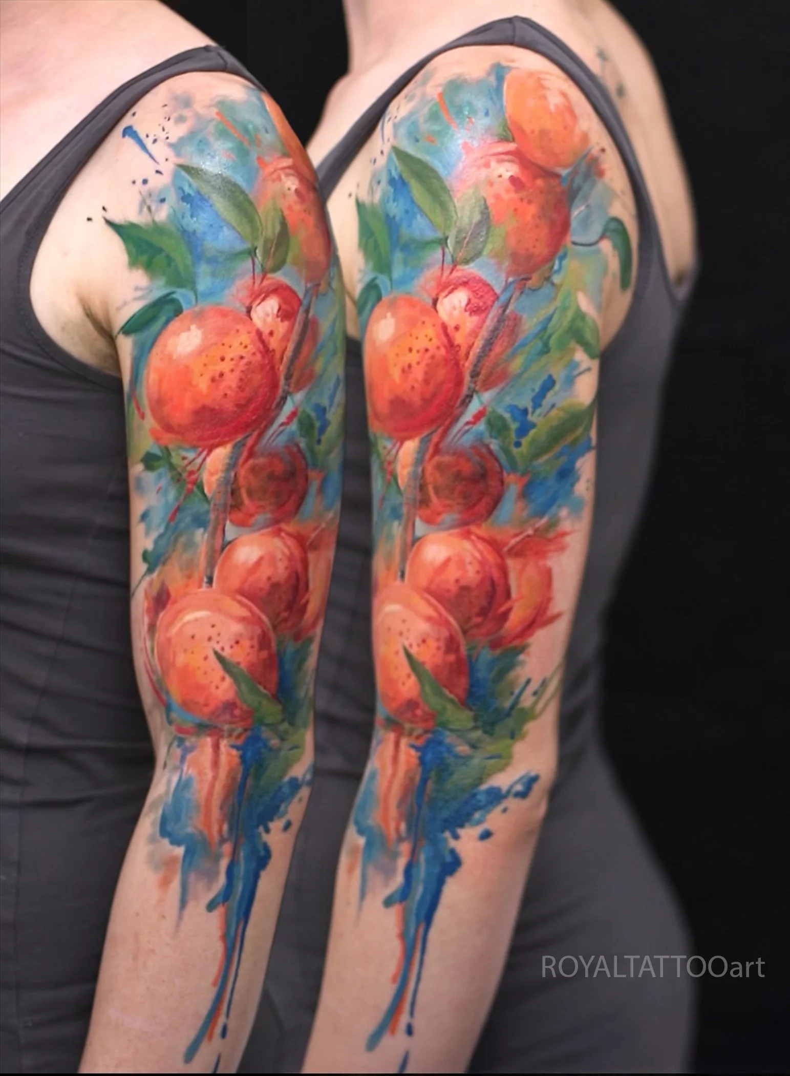 Vibrant watercolor pomegranate fruit tattoo sleeve with bold red and blue tones, abstract botanical ink art by Royal Jafarov at Royal Tattoo Art