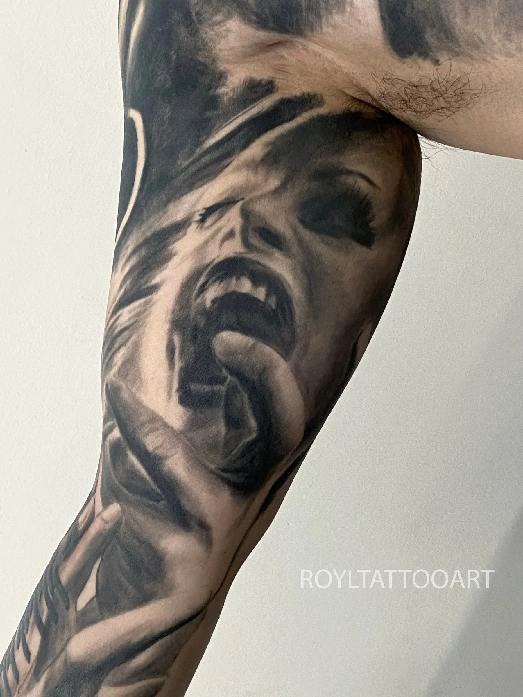 Black and grey horror portrait realism tattoo with dark atmosphere, dramatic shading, and cinematic detail by Royal Jafarov in Manhattan.
