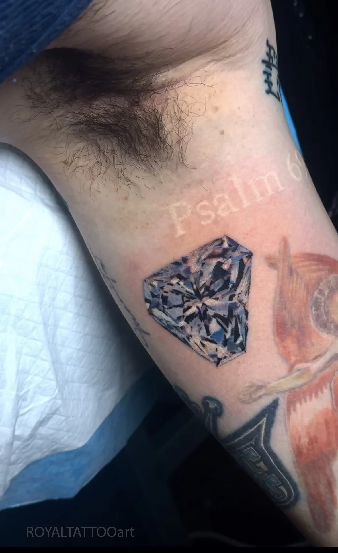 Realistic diamond tattoo with sharp faceted details, blue-grey reflections, and high-contrast black shading, created by Royal Tattoo Art in NYC