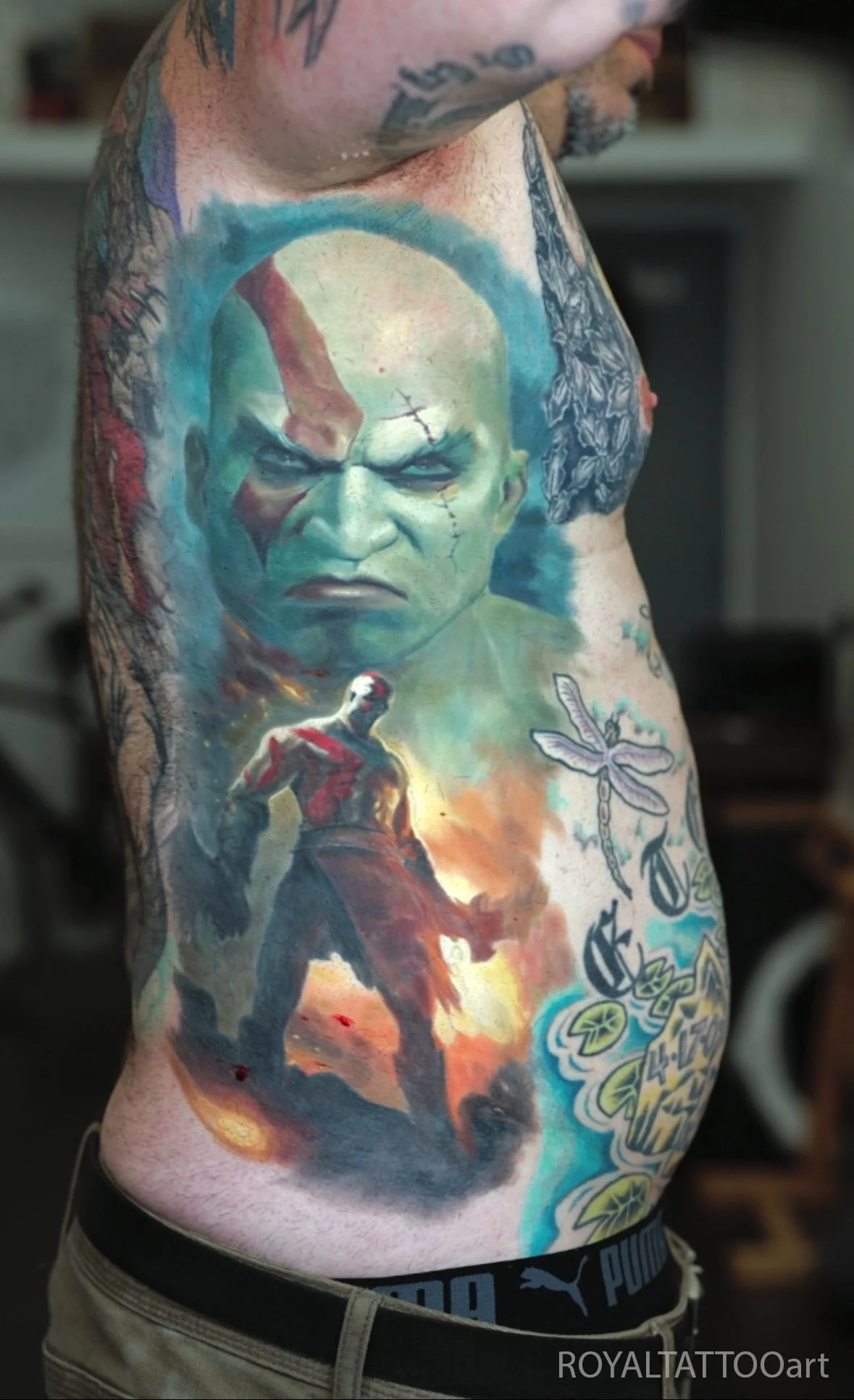 A bold color realism tattoo of a powerful green figure in a dynamic action scene, rendered with intricate shading.