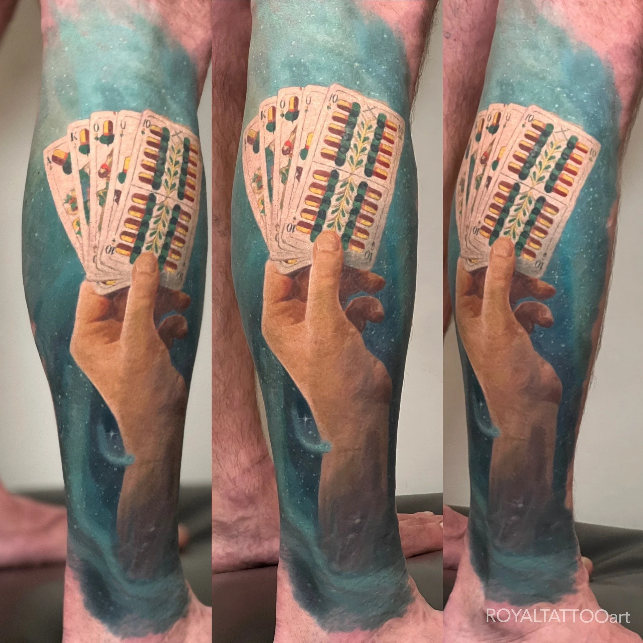 A surreal pair of calf tattoos depicting hands clasping playing cards against a cosmic, space-themed backdrop, executed in vivid color realism.