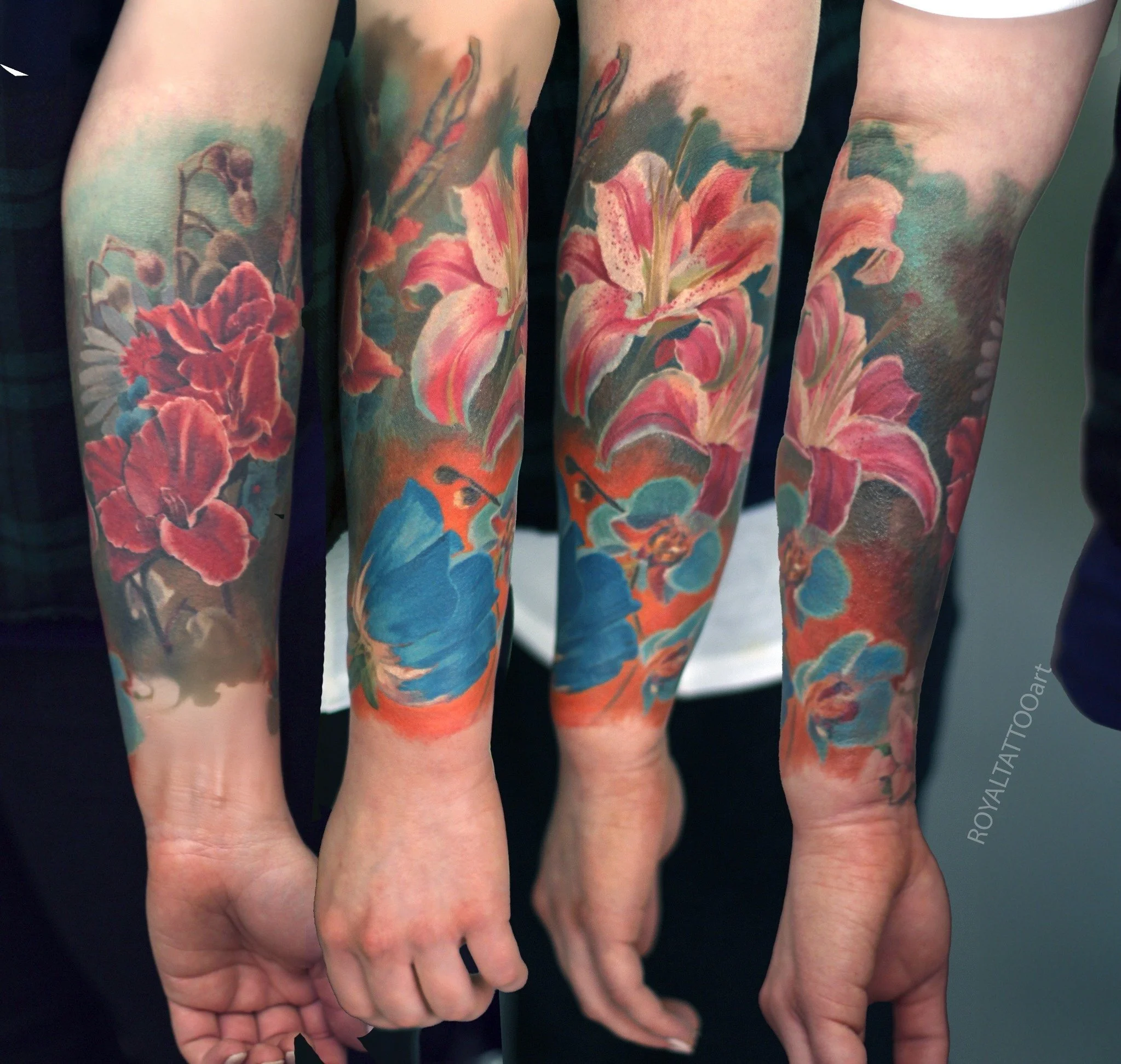 Matching forearm tattoos of vivid pink blossoms and surrounding blue and green hues, rendered in bright color realism.