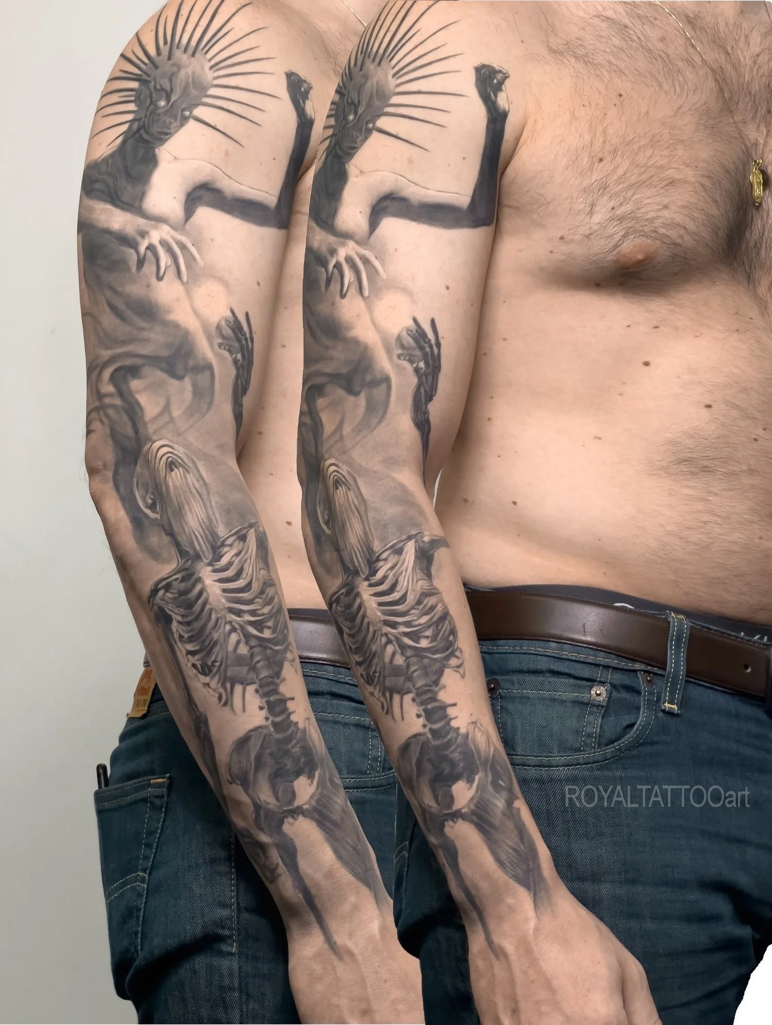 Black and grey surreal realism sleeve tattoo featuring demon and skeletal imagery with dark shading and dramatic custom composition.