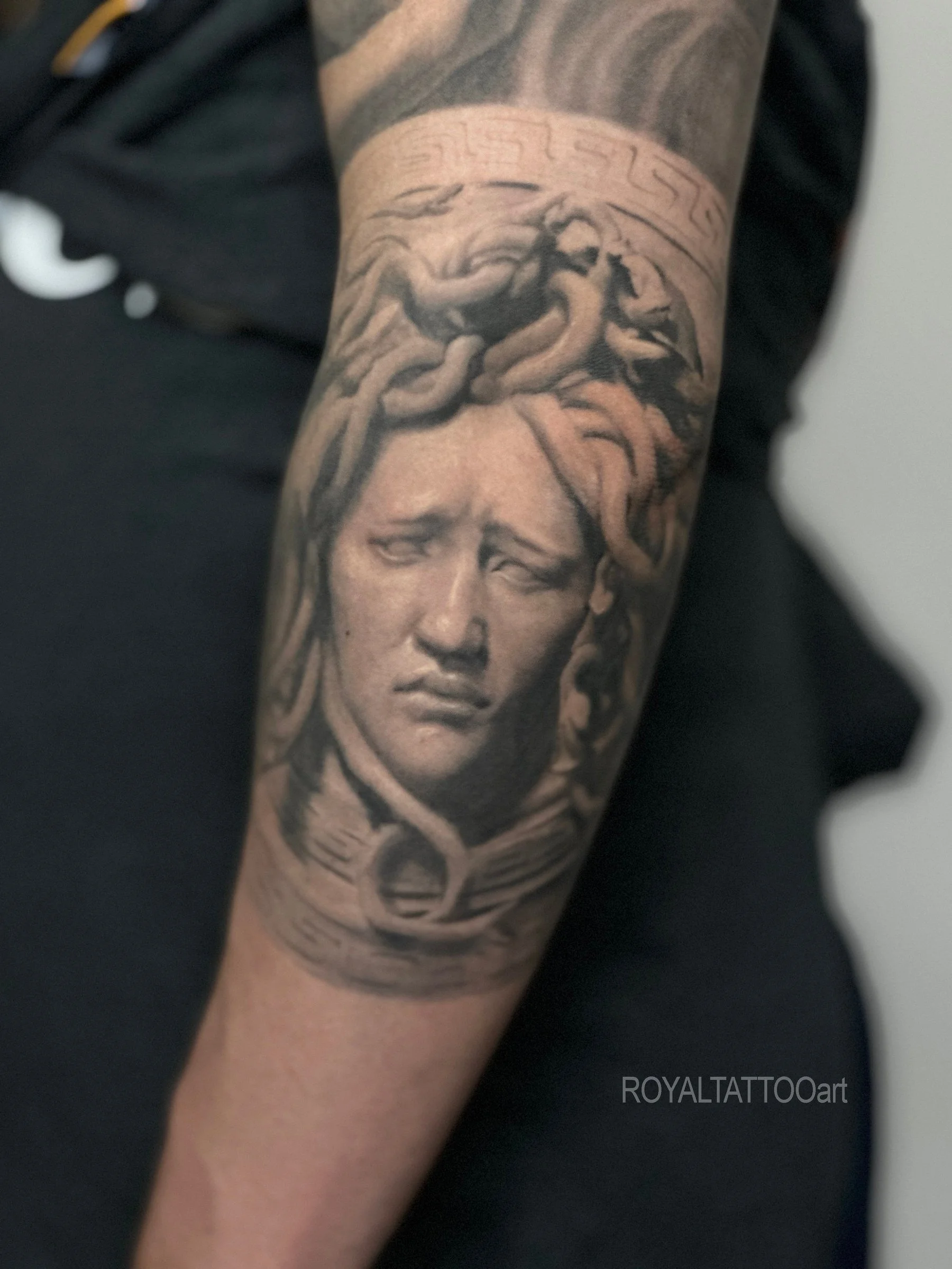 Black and grey Medusa Greek mythology portrait tattoo, designed with classical statue influence, snake details, and realistic shading by Royal Jafarov in NYC