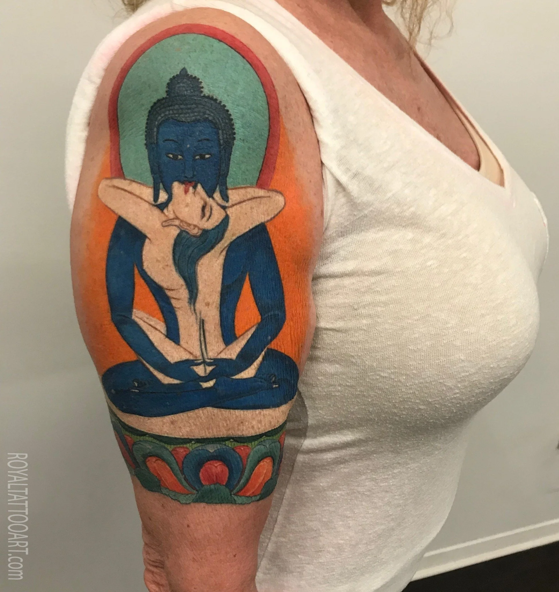 Mystical Buddhist tantric blue figure realism tattoo on the arm, created in NYC. Royal Tattoo Art captures the spiritual depth and vibrant symbolism of Vajrayana Buddhist iconography in breathtaking color realism, perfect for lovers of sacred and eso