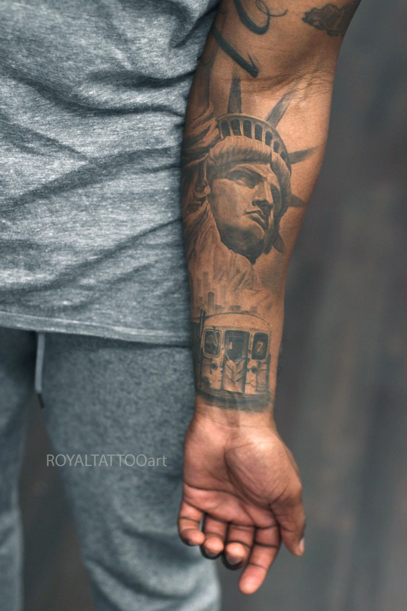 Black and grey Statue of Liberty realism tattoo with NYC symbolism, detailed shading, and a clean Manhattan-inspired composition.
