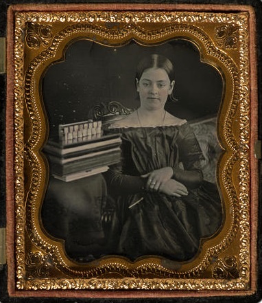 Young Woman Sitting Next to Books