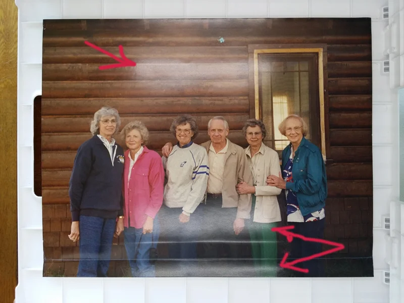 You can see two bright strips of reflected light where the light bulbs reflect off the shiny surface of the photo.