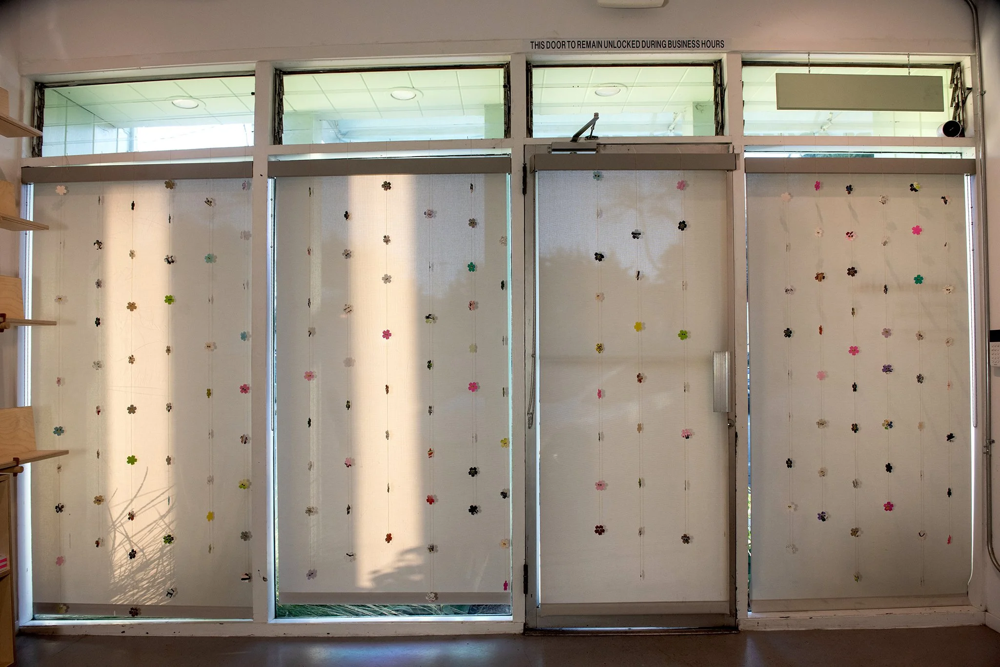 Sakura Window Installation, 2025, origami paper, studio papers, googly eyes, thread, dimensions vary