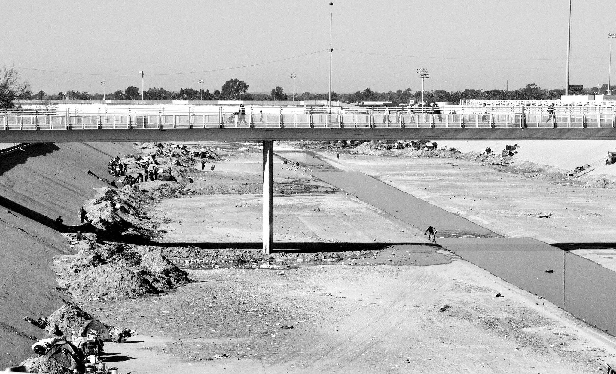 Gathering The Tijuana River, known as “El Bordo,” has become a place of refuge for thousands of Mexican and Central American migrants. The riverbank extends 2.5 miles along the U.S.- Mexico fence. Migrants have built and excavated “pocitos.” Pocitos are tunnels in which migrants - men and women - live in hiding from any potential assault of police or organized crime.
