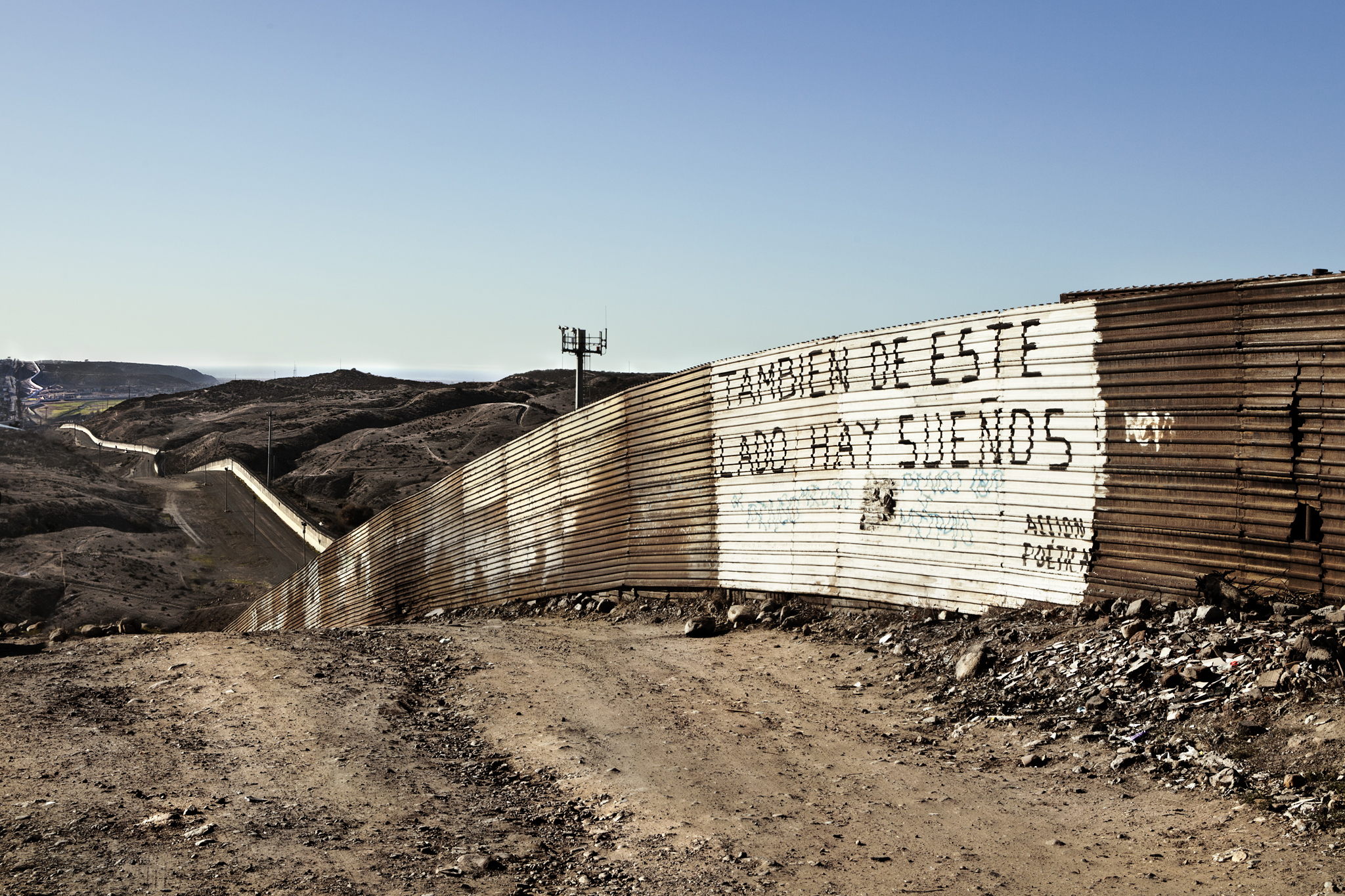 Tijuana Border The border stretches further than the eye can reach. It hugs the hillside, oblivious to its own significance in the lives of the incalculable souls seeking opportunity on its U.S. side. On and on la linea extends. The captured advertisement of dreams existing on this (its Mexican) side is less than convincing to those in search of a better life. 