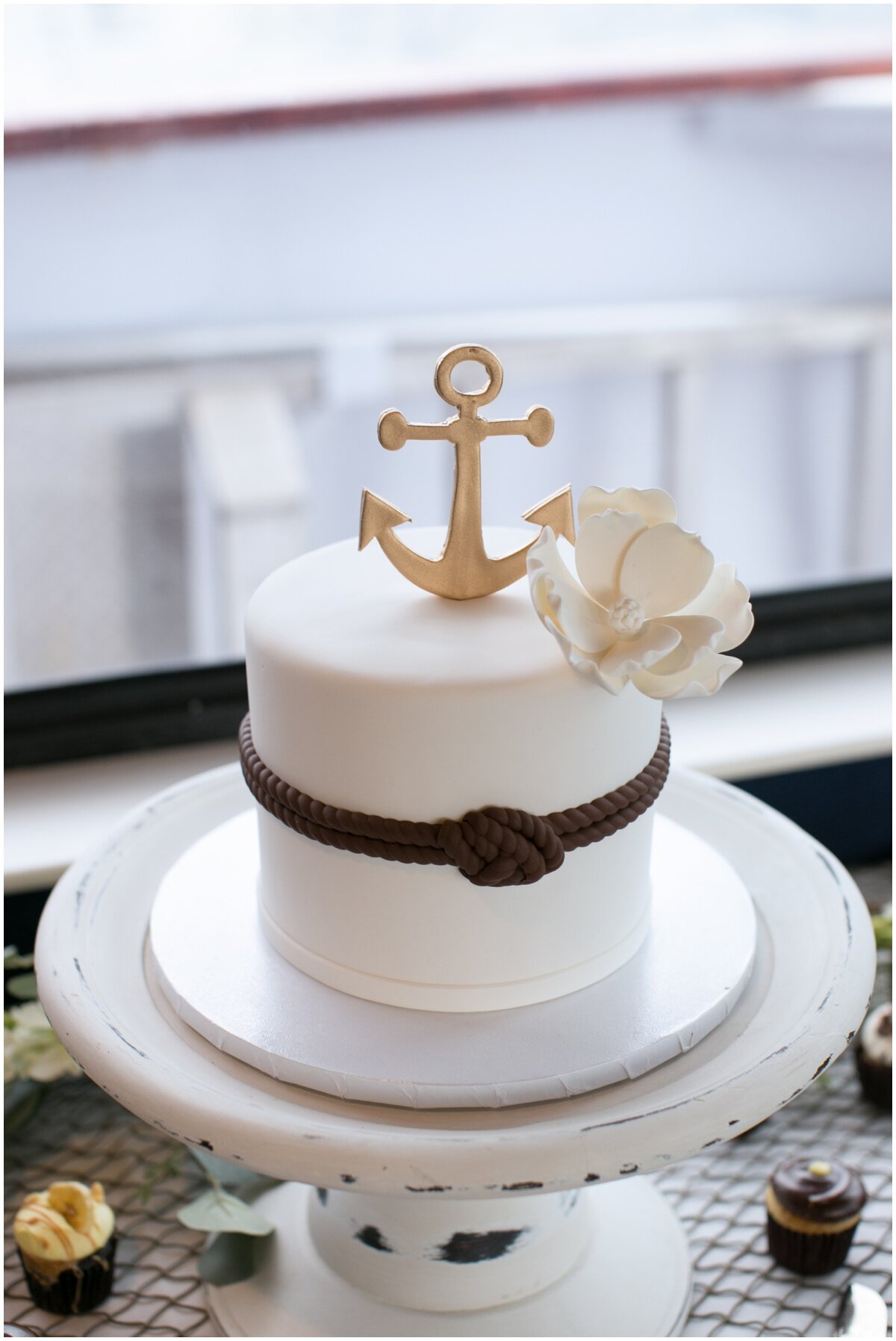  white wedding cake with anchor topper 