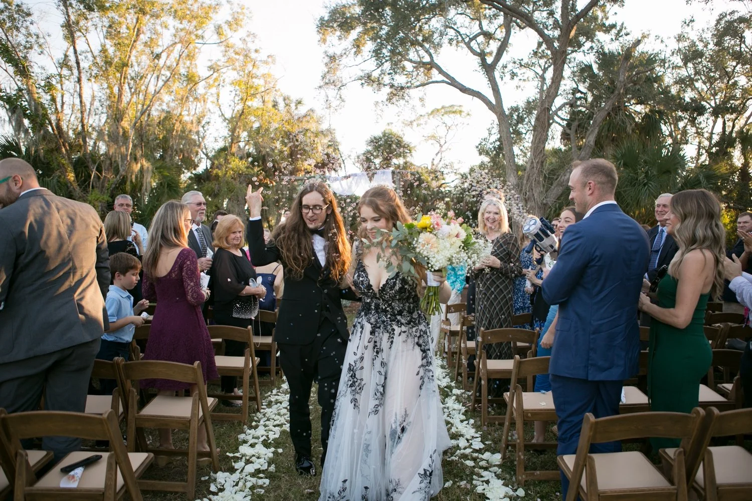 Newlyweds walking down the aisle to bubble cannon exit at Fat Beet Farm Tampa wedding