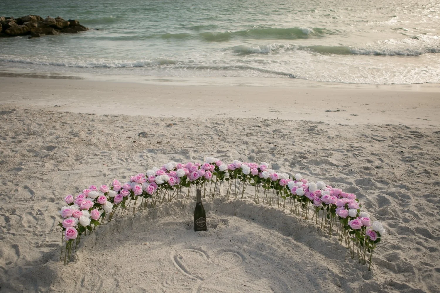Pink and white rose arch with Argyle Oregon sparkling wine in the sand at Upham Beach, St. Pete Beach