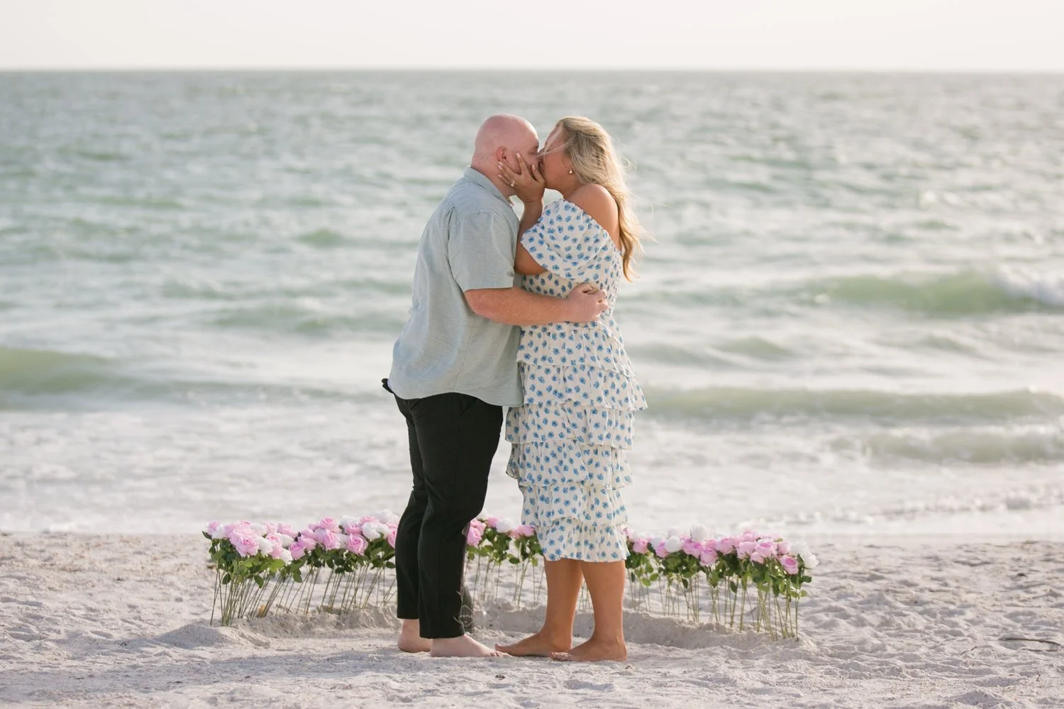 Newly engaged couple sharing a kiss by the Gulf after their St. Pete Beach proposal