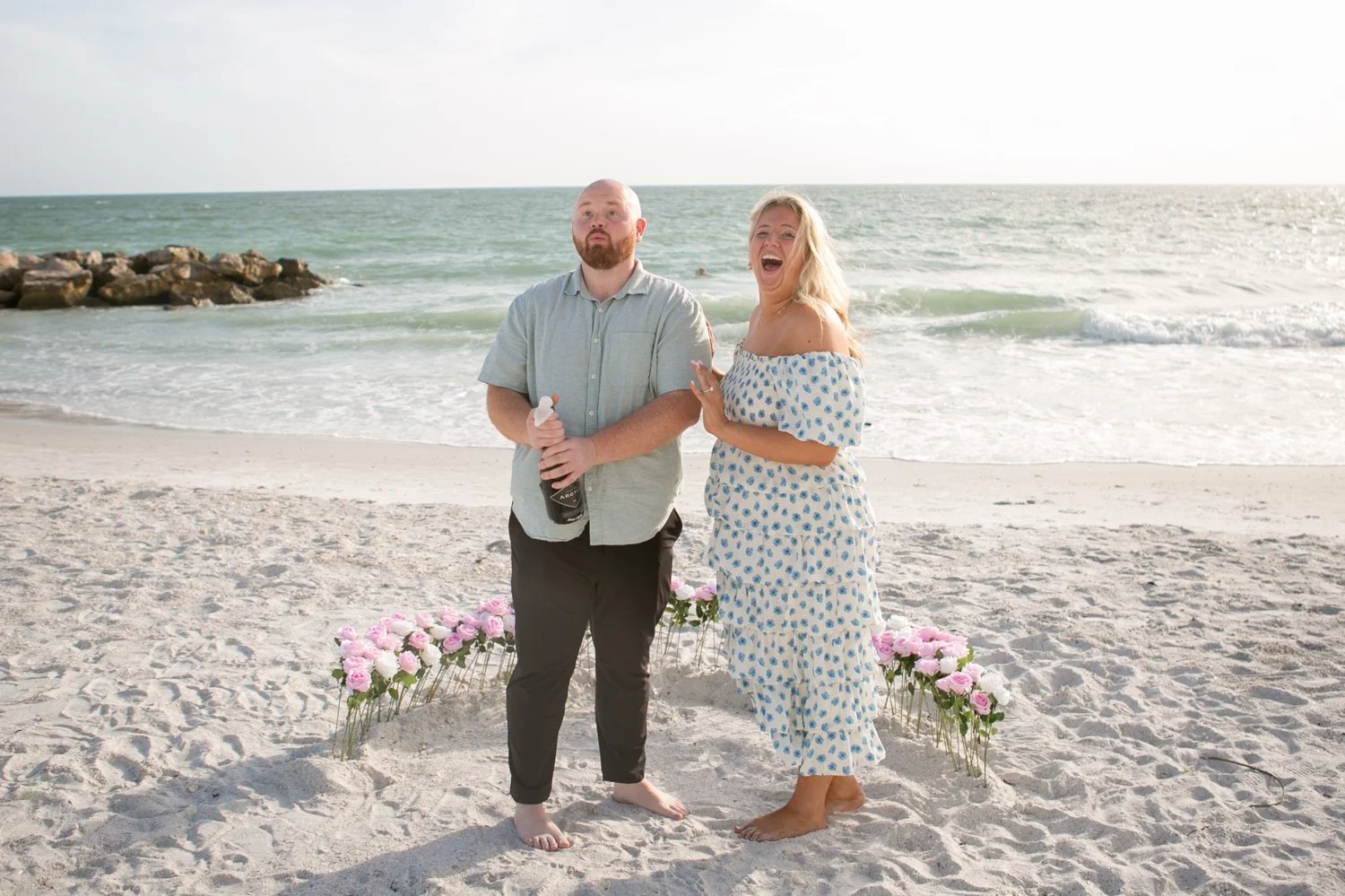 Just-engaged couple celebrating with sparkling wine on St. Pete Beach