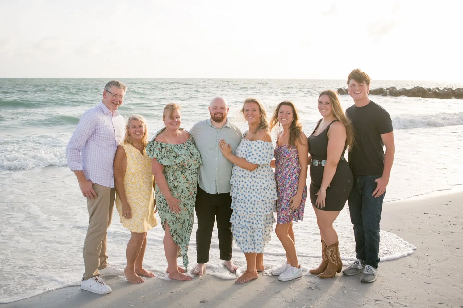 Family group portrait on the beach celebrating a surprise engagement at Upham Beach